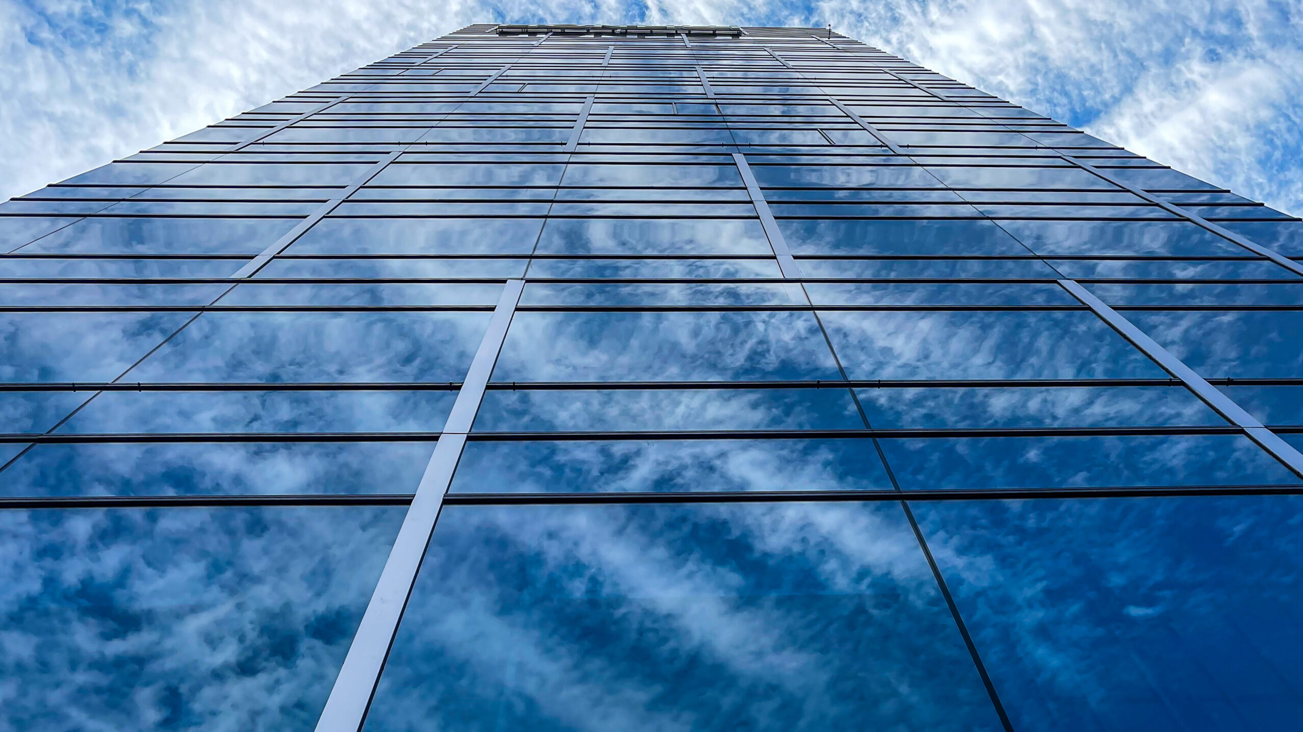 Beautiful modern tall tower with clouds in financial district. Windows skyline